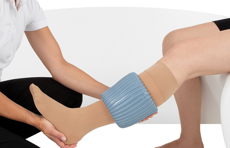 Persoon helpt bij het aantrekken van een steunkous met een speciale aantrekhulp